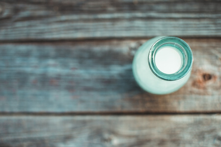 on a wooden surface, the table is a bottle of milkの写真素材