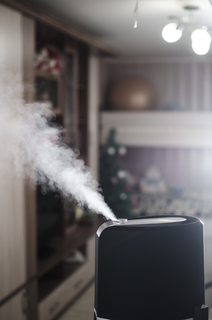 The steam from the humidifier at night in the dark blackの写真素材