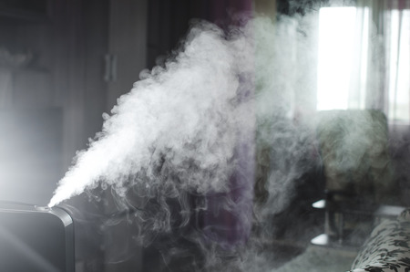 The steam from the humidifier at night in the dark blackの写真素材