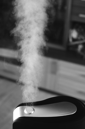 The steam from the humidifier at night in the dark blackの写真素材