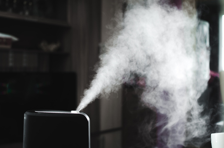 The steam from the humidifier at night in the dark blackの写真素材