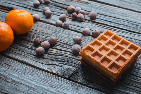 waffles, next to acorns and tangerines, rustic style On wooden backgroundの写真素材