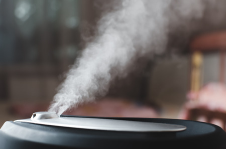 The steam from the humidifier at night in the dark blackの写真素材