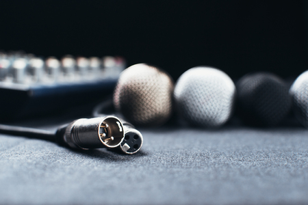 Gray on the table are microphones next to the remote, all on a black backgroundの写真素材