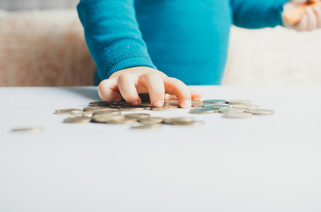 child coins hands in the stack of coinsの写真素材