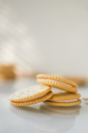 Round cookies with white filling on a light background, with light from the window is very softの写真素材