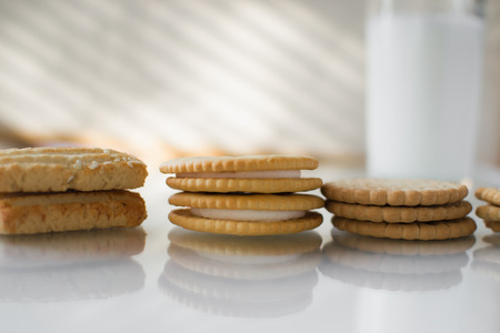 miscellaneous cookies, next to milk on a soft light background, homemade, rustic with light from the windowの写真素材