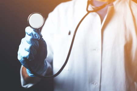 Stethoscope close-up, close the doctor holds in his hand on a black backgroundの写真素材
