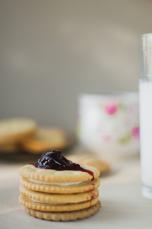 cookies with filling next with a glass of milk nicely at home, on top of the jamの写真素材