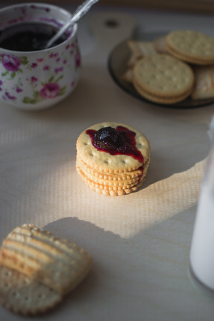 cookies with filling next with a glass of milk nicely at home, on top of the jamの写真素材