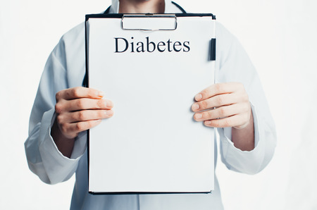 The doctor is holding a clipboard, where he wrote the diagnosis of diabetesの写真素材