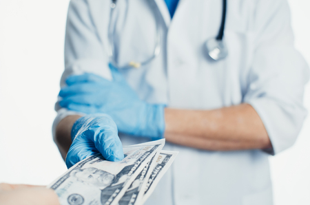 The doctor takes the money, it's a bribe or gratitude for the workの写真素材