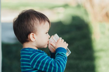 charming boy in nature drinking Apple juiceの写真素材