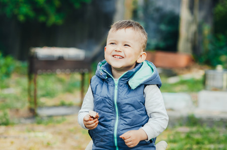 baby, little boy eating a piece of shish kebab meat, outdoors