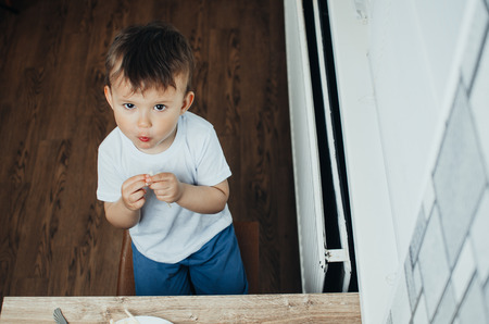 baby eating pasta with sausage top viewの写真素材