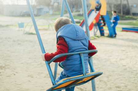 Little baby swinging on the swing and not afraidの写真素材