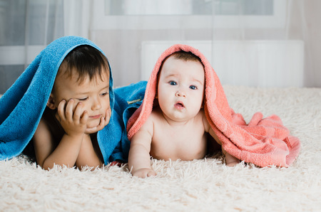 Brother and sister lie with towels on their heads, family love, younger and older