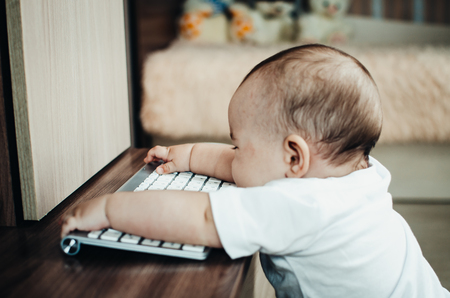 Child's hands typing on keyboard in the officeの写真素材