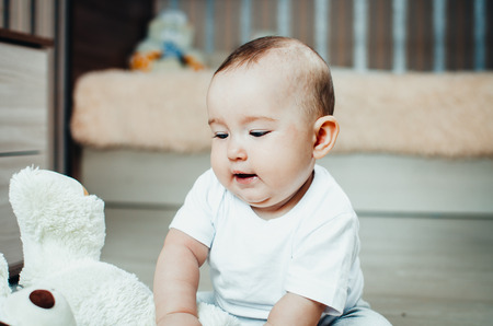 baby on the floor playing with soft toy, dirty and dustyの写真素材