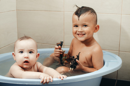 children, brother and sister in the bathroom swimming, playing splashing
