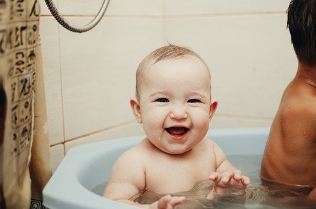 children, brother and sister in the bathroom swimming, playing splashingの写真素材