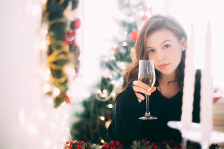 Beautiful girl with a glass of champagne, Christmas atmosphere, new yearの写真素材