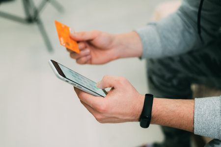 Online payment, hands holding credit card and using smartphoneの写真素材