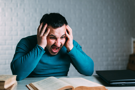 Man reading a book and nervous screams can't rememberの写真素材