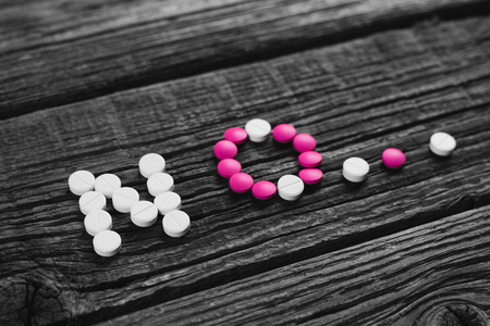 The word no on a wooden background lined with white and pink tabletsの写真素材