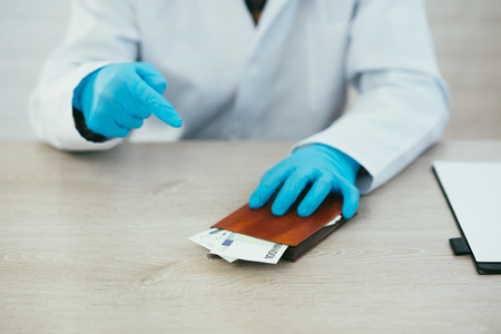 The doctor was offered a bribe put in a notebook not to give in hand
