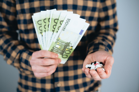 Money and pills in hand, Spending too much money on drugs. The concept of addictionの写真素材