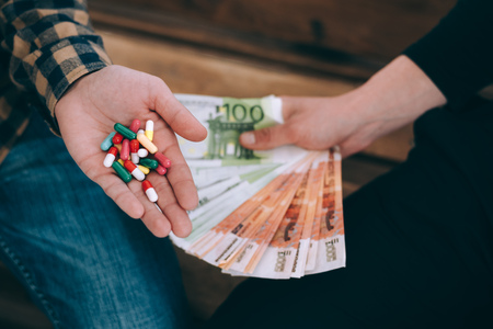 men on the bench selling drugs or pills for rubles close-upの写真素材