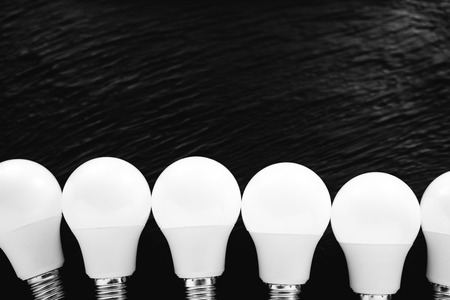 led light bulbs white light on a black textured background with place for inscription