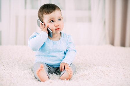 A little girl talking on a smartphone smiling and happy