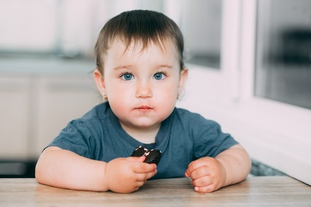 A little girl in the kitchen eating marshmallows in chocolate or chocolate chip cookies is very tastyの写真素材