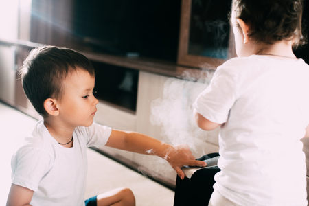 Children, brother and sister near humidifier, from which goes steam.The concept of humidity in the houseの写真素材