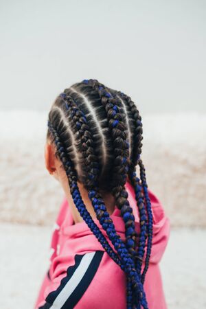 Braids with artificial material woven beautifully and fashionably, on a little girl cool