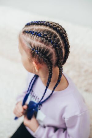 Braids with artificial material woven beautifully and fashionably, on a little girl cool