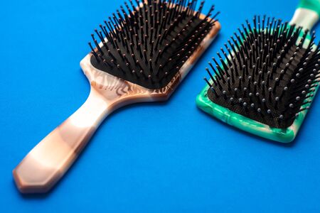 Two combs brown and green on a blue background cool