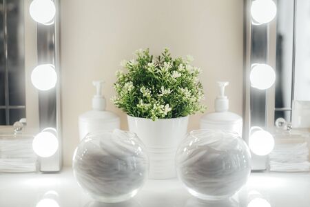 Light background and place for make-up artist, a glass bulb with a cotton pad on the center of the...