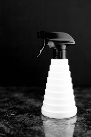 hairdressing spray gun is located on a black marble slab, with black and white colors on a backgroundの写真素材
