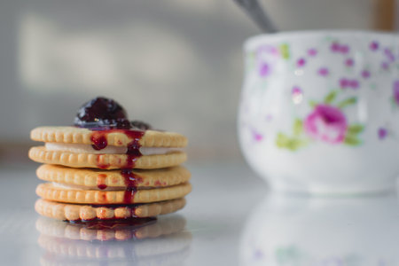 cookies with filling next with a glass of milk nicely at home, on top of the jam