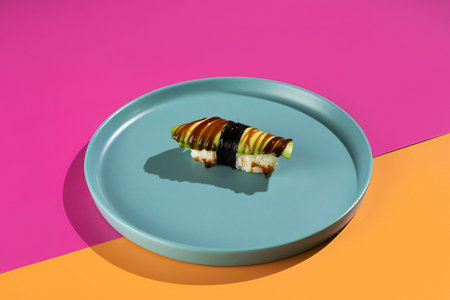 A plate of food with a green vegetable on it. The plate is blue and the background is pinkの写真素材