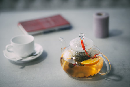 Glass teapot and cup on a table in a cozy setting, waiting to be used.の写真素材