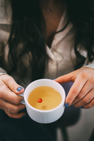 Woman holding a cup of tea, perfect for relaxing moments, mindfulness, and wellness promotion