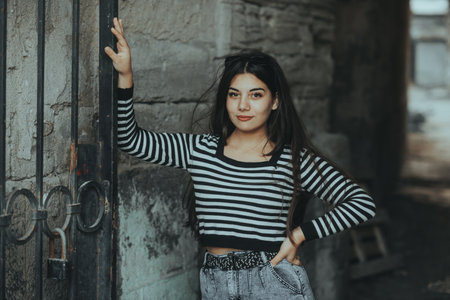 Relaxed woman sitting outdoors in the city, symbolizing balance and tranquility in urbanの写真素材