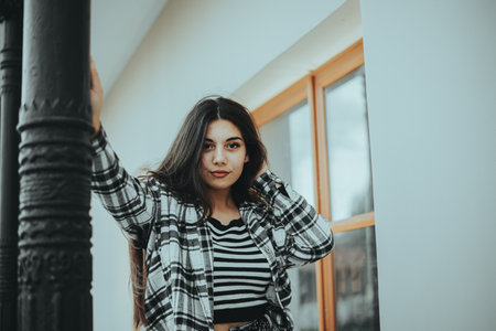 A stylish woman relaxing against a fence.の写真素材