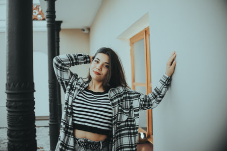 A stylish woman relaxing against a fence.の写真素材