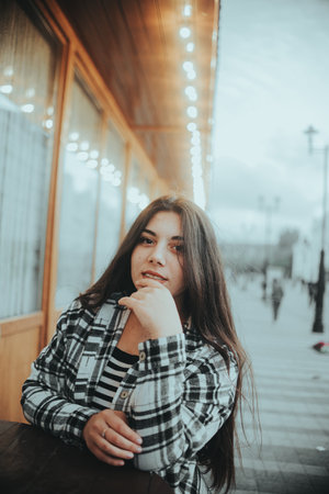 A thoughtful brunette looks out of the window, lost in her thoughts.の写真素材