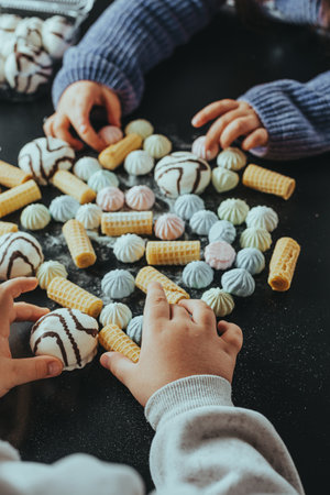 Children's hands reaching for marshmallows, wafersの写真素材